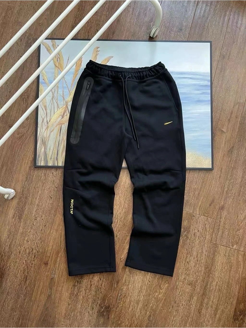 Black track trousers laid flat